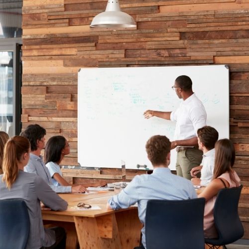 Managing And Improving Processes For Unbelievably Successful Operations Image of a person giving a presentation to stakeholders.