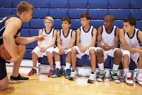 Image of a coach rallying and motivating his team for a game for the coaching leadership style.