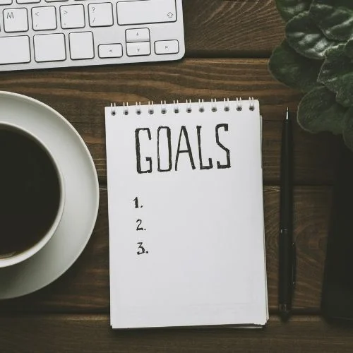 22 Tips to Make Your LinkedIn Profile Stand Out Image of a coffee cup and notebook with goals on it for LinkedIn profile tips and tricks section 2. Understand your goals on LinkedIn.