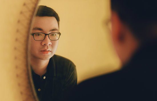 Image of a man looking in a mirror representing self-reflection for self-leadership strategies.