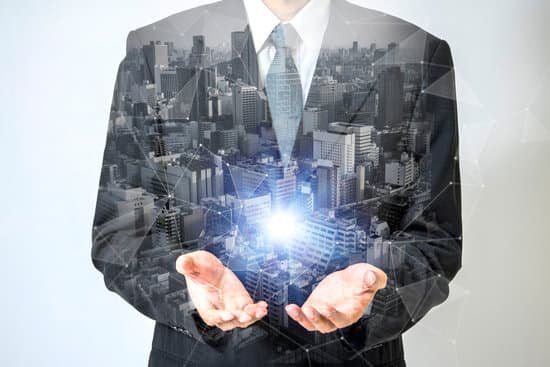 Discover The 12 Essential Qualities Of A Good Leader Image of a businessman holding a ball of light in his hands representing the vision leadership trait.