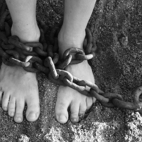 Image of a person shackled at the feet.