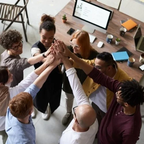 Image of a group embracing after a work meeting.