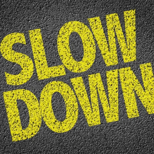 Image of the words slow down written on a road representing the need to not rush during a negotiation.