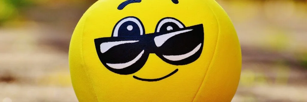 21 Expert Tips To Handle Disrespect In The Workplace Image of a smiley face with sunglasses.