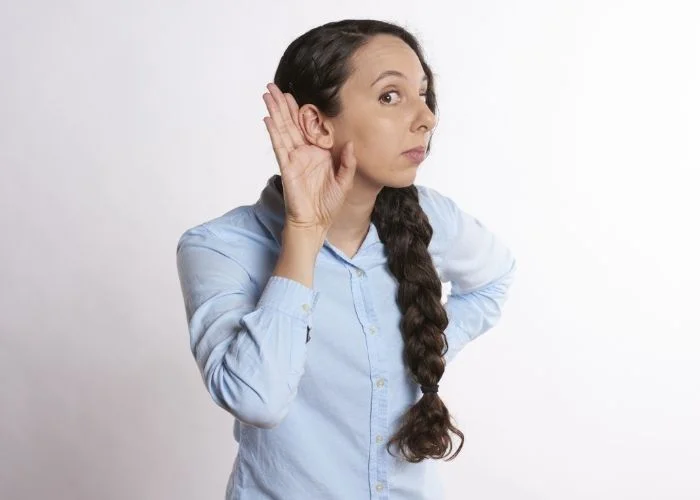 How to Build Strong Relationships at Work! 26 Tips Image of a lady holding her hand to her ear for listening.