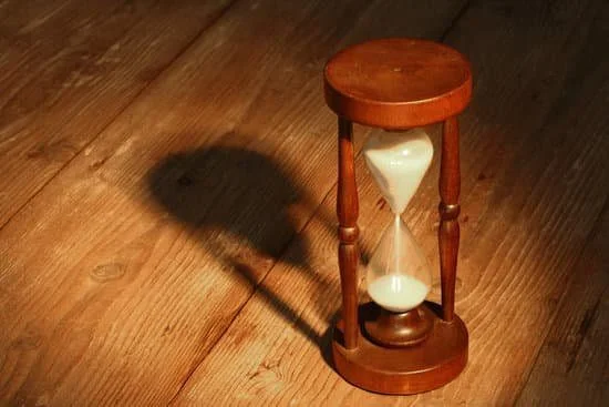How to Be More Productive In Life: 14 Actionable Tips Image of sand running through an hour glass to represent an impending deadline.