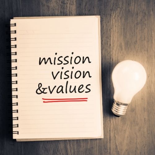 Image of notebook with mission, vision, & values on it explaining what is a legacy.