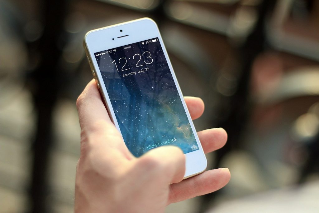 12 Tips For Successfully Managing a Remote Team Person, leader, boss, supervisor, manager using cellphone representing the use of technology for managing teams.