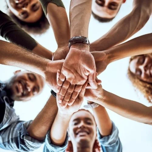 Image of team members putting their hands together representing trust.