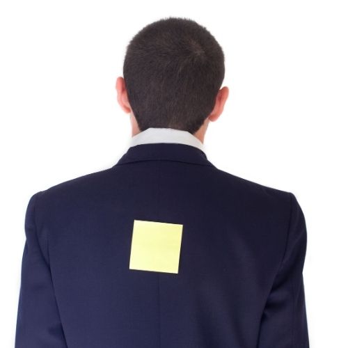 10 Fun Team Building Activities That Employees Will Love Image of person with note on his back for Matched Pairs team building game.