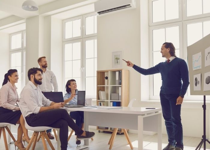 What Is Strategic Leadership and Management? How to Use It Images of a leader giving a presentation on strategic leadership.