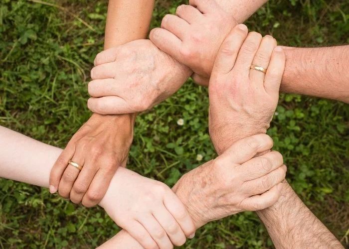 How to Build Trust in the Workplace: 12 Actionable Tips Interlocked arms for building trust in the workplace.