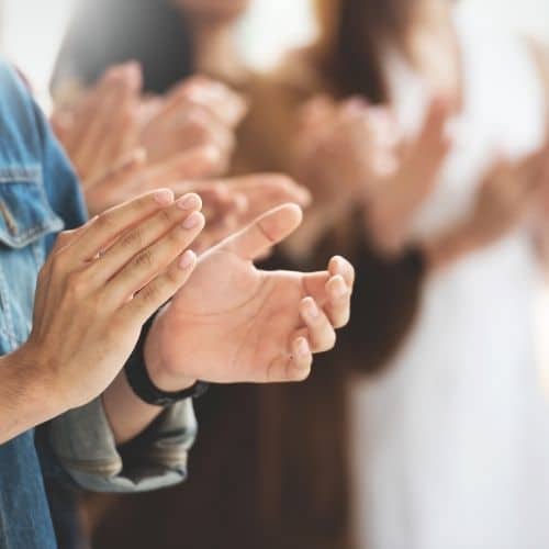 Image of co-workers clapping for recognition virtual team building activity. 