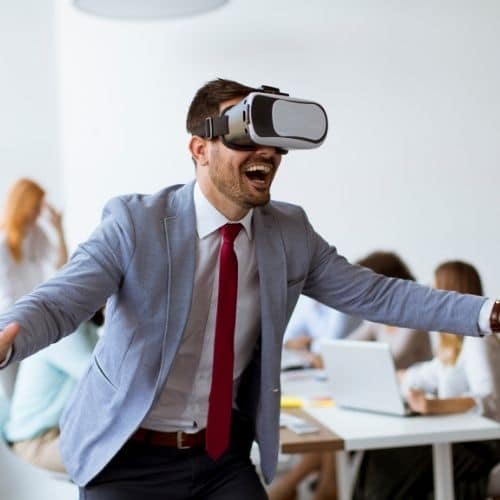 Image of busniess man wearing VR goggles for challenges section in virtual team building activities and virtual icebreakers article.