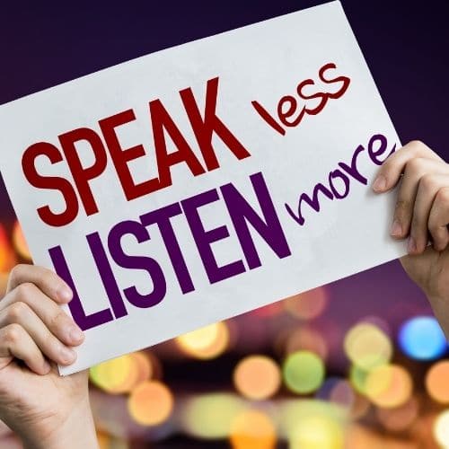 Image of a person holding up a sign saying speak more, listen less.