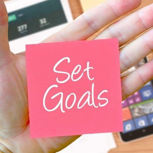 Improve Your Multitasking Skills: 8 Expert Tips to Get More Done Image of a sticky note saying set goals. Goals will improve your multitasking skills.