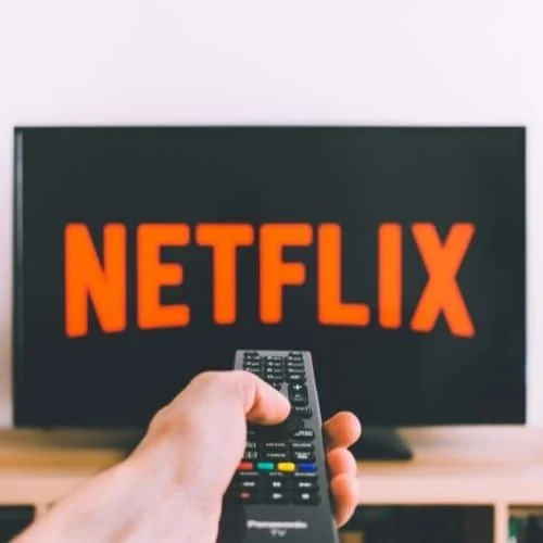 Improve Your Multitasking Skills: 8 Expert Tips to Get More Done Image of a person watching Netflix.
