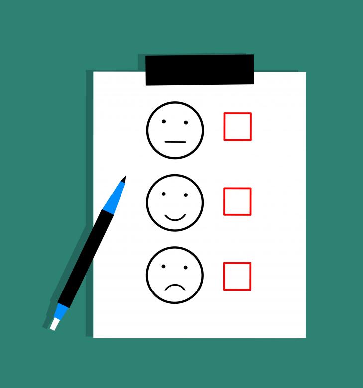How to Be a Good Communicator (24 Powerful Tips) Piece of paper with happy, neutral, and frowned faces with checkmarks next to them to represent feedback.