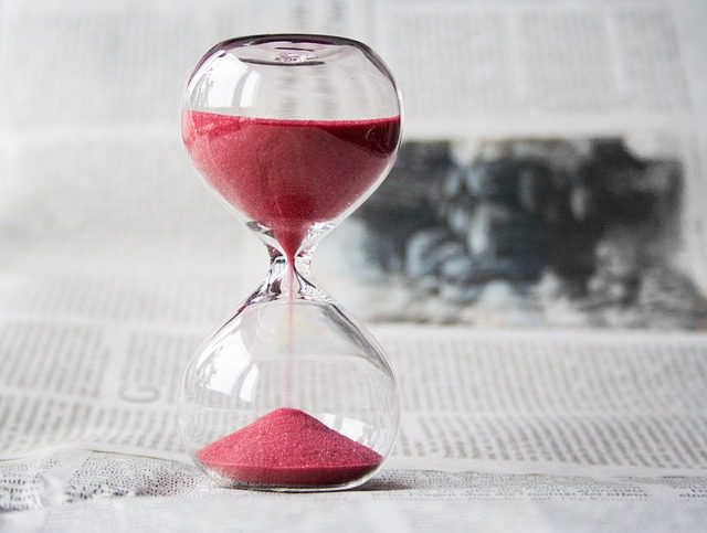 Hourglass with sand running through it.