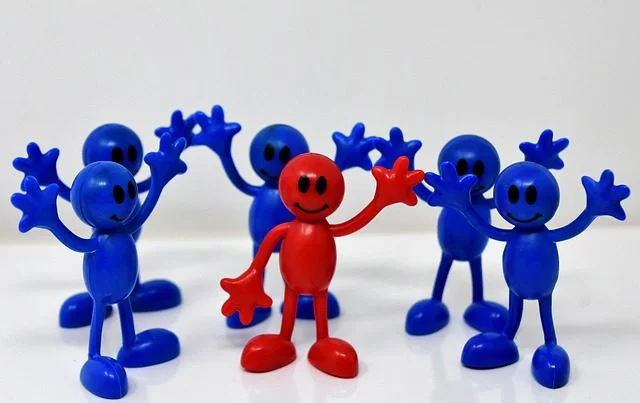 How to Build Trust in the Workplace: 12 Actionable Tips One red figure with five blue figures around him all waving empowering a happy team for ways to build trust at work.