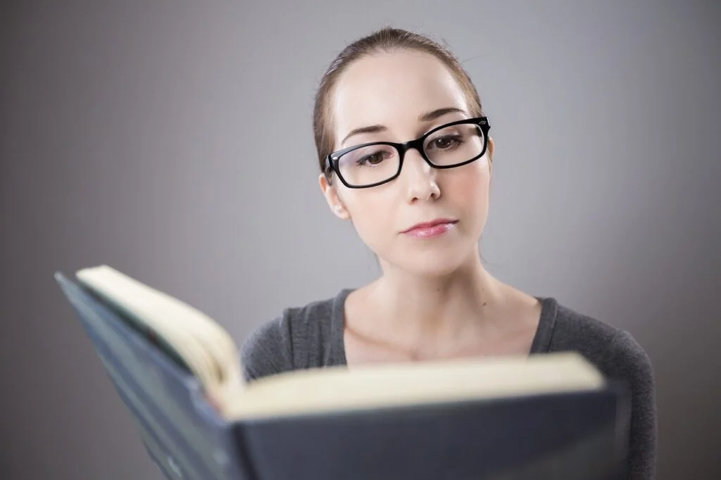 Job vs Career: Punching the Clock or Pursuing Your Passion Woman reading a book to help her get out of her dead-end job and get a better career.