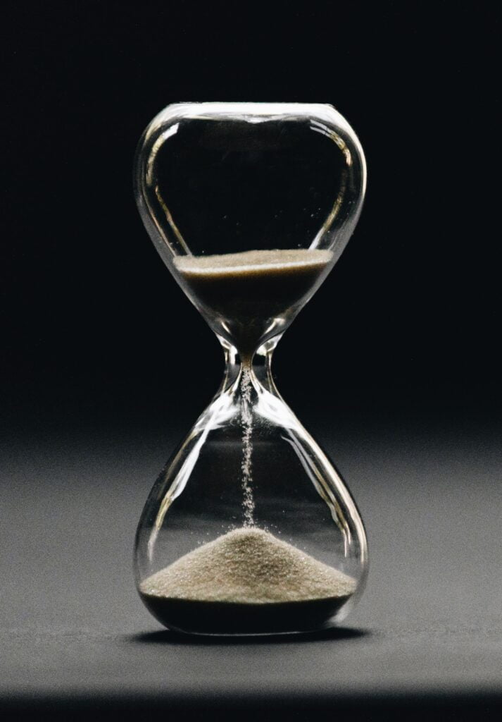 23 Effective Time Management Techniques to Get More Done An hour glass running out of time to show the importance of time management.