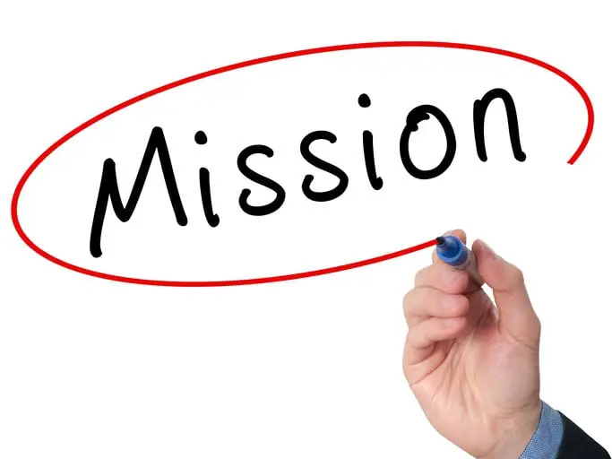 What Is a Personal Mission Statement? How to Write Yours image of a person's hand writing mission for what is a personal mission statement.