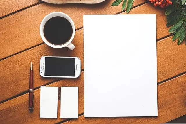 What Is a Personal Mission Statement? How to Write Yours coffee, cellphone, and blank notebook for writing a personal mission statement template on.