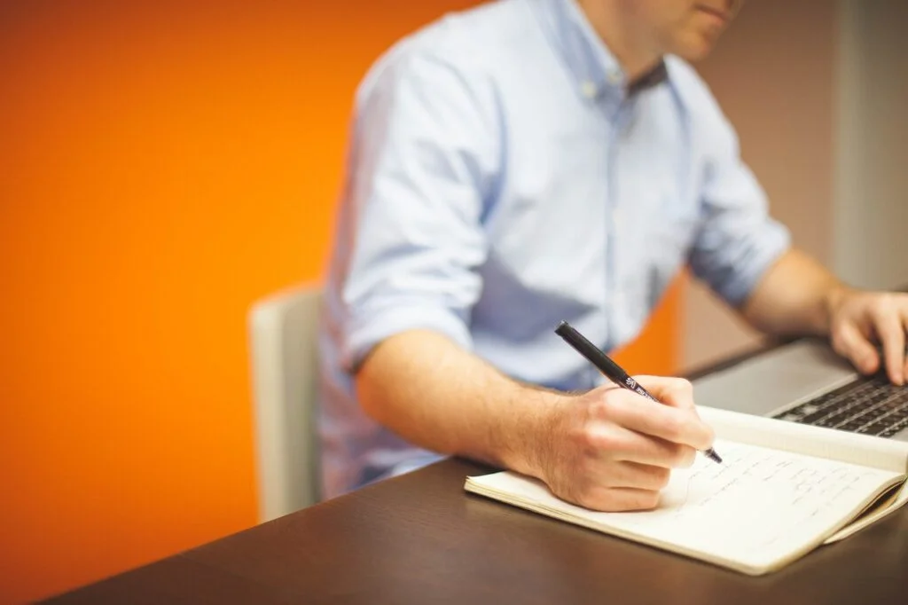 Mastering the Rapid Planning Method (RPM) for Productivity person writing down the steps for the rapid planning method.